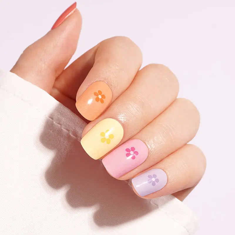 Semi-cured gel nail wraps in glossy pastel orange, yellow, pink and lilac with tiny flower accents