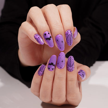 Purple nail wraps with black spiderwebs, pumpkin face, bats and star Halloween design