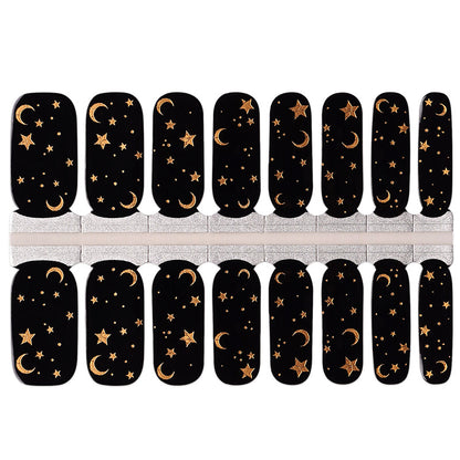 Black nail wraps with gold celestial moon and star design, glossy finish