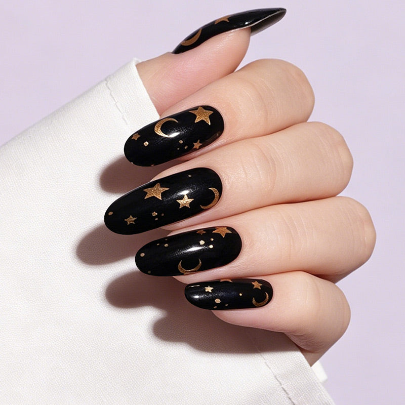 Black glossy nail wraps with gold moon and star celestial design, almond shape