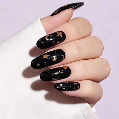 Black glossy nail wraps with gold moon and star celestial design, almond shape