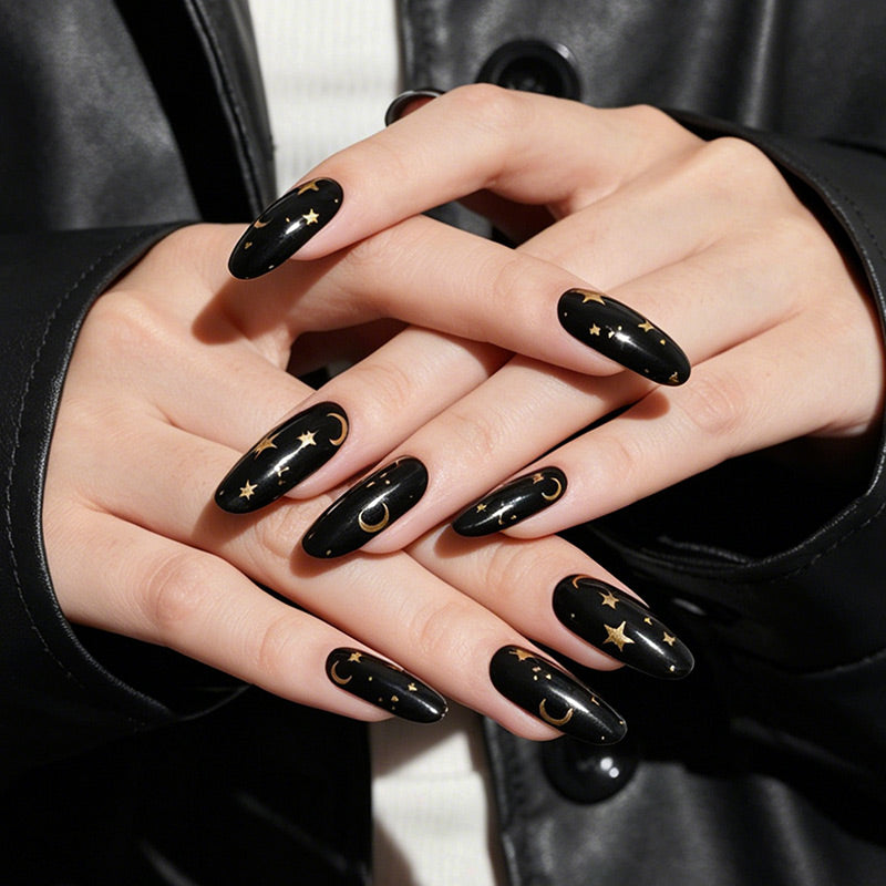 Black glossy nail wraps with gold moon and star celestial design, almond shape