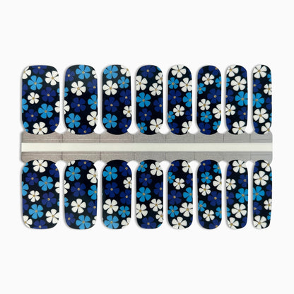 Navy nail wraps with blue and white floral pattern, gold glitter flower centres.