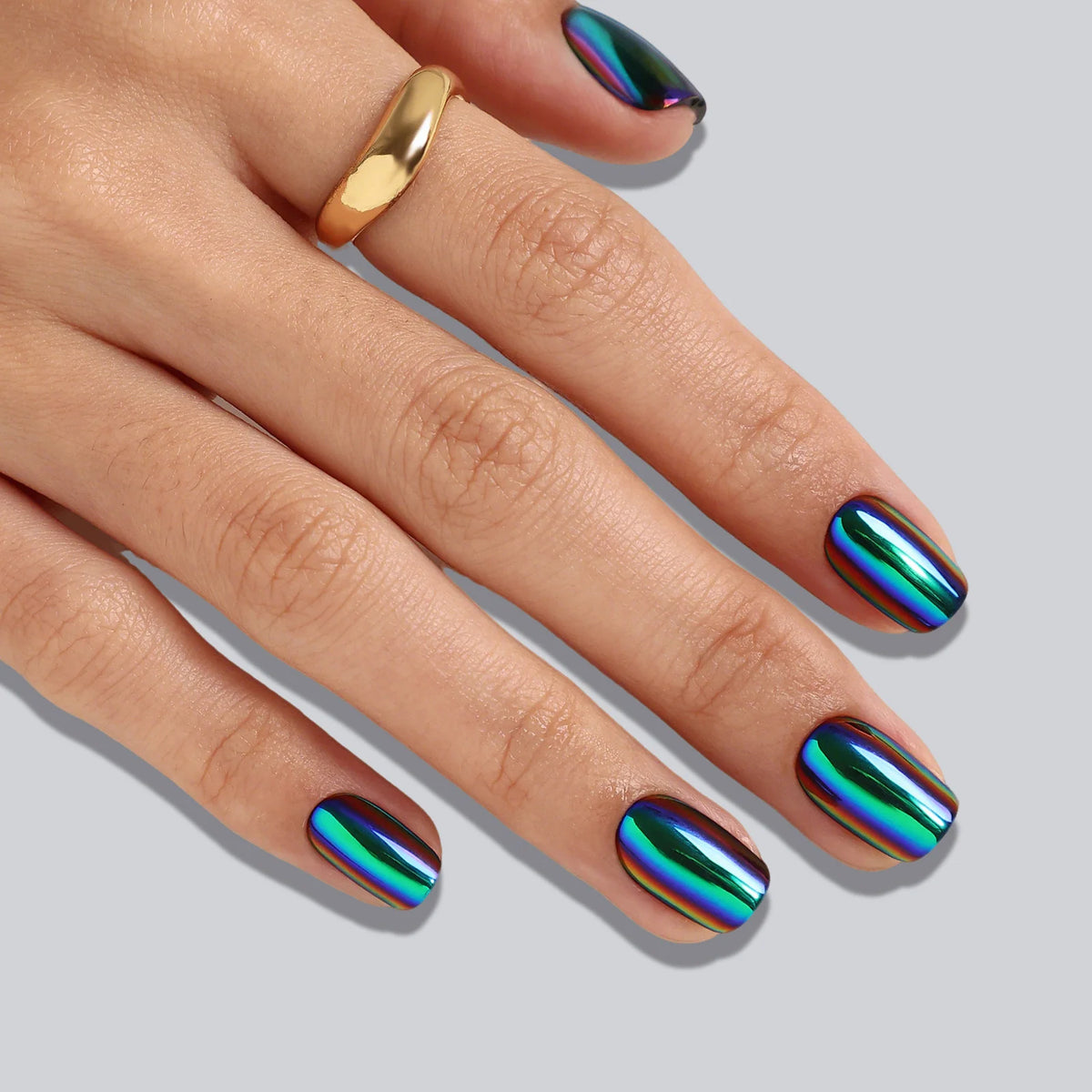 Short square soft gel press-on nails with oil-slick chrome finish in blue, green and purple tones.
