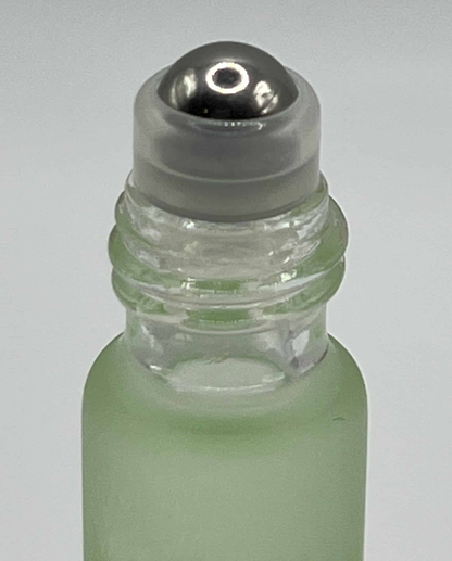 Close-up of green aloe cuticle oil rollerball applicator for precise nail treatment