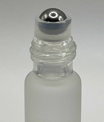 Close-up of frosted glass cuticle oil rollerball applicator with silver cap