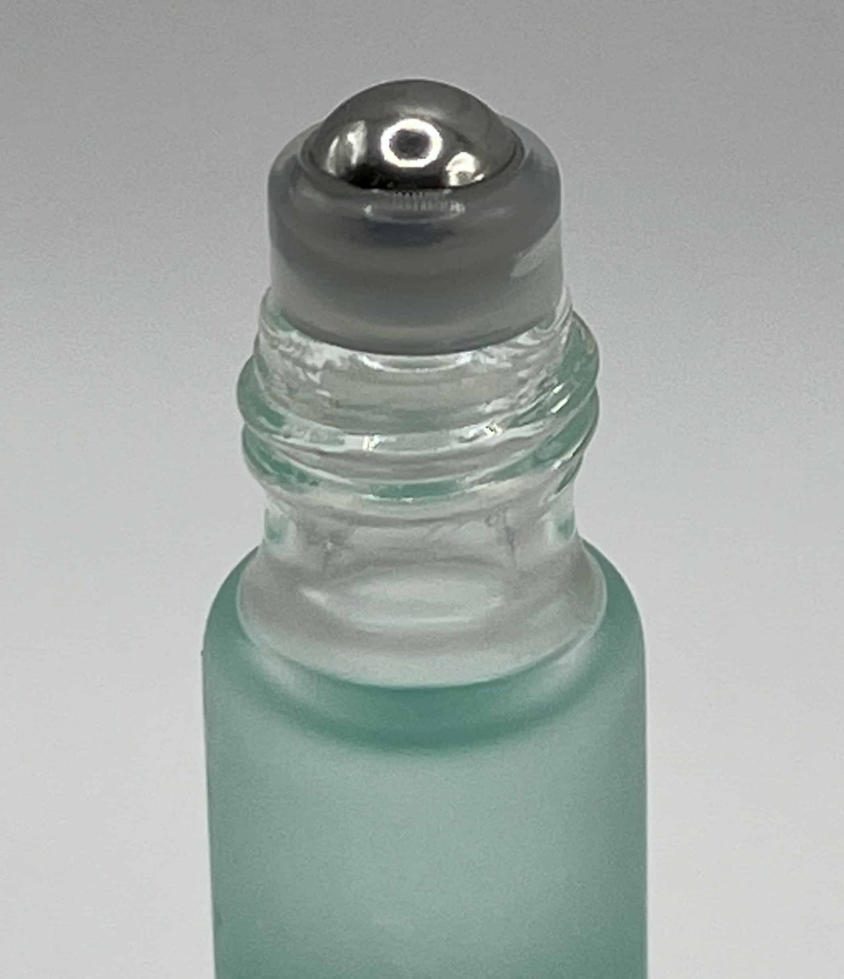 Cuticle oil bottle with roll-on applicator for nail treatment and care