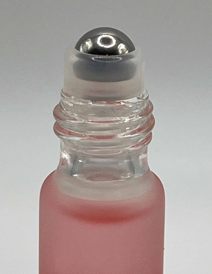 Close-up of rose cuticle oil roller ball applicator for precise nail treatment
