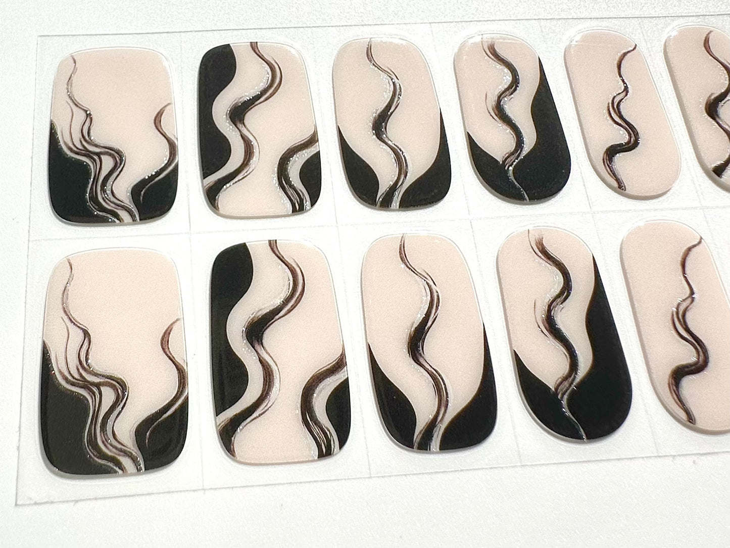 Close-up of black and white marbled smoke pattern gel nail wraps sheet