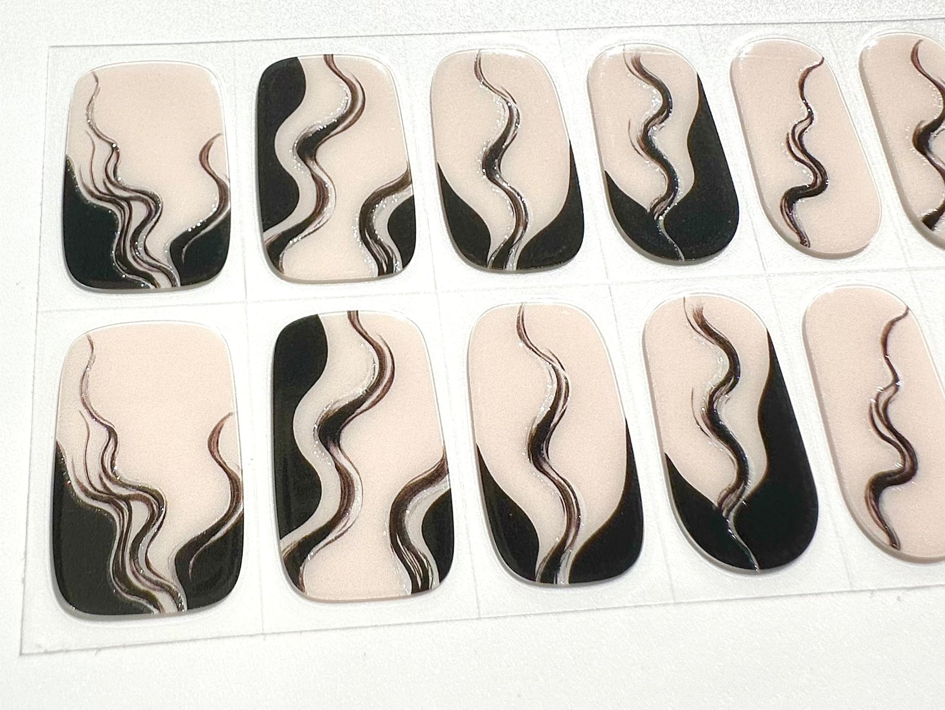 Close-up of black and white marbled smoke pattern gel nail wraps sheet