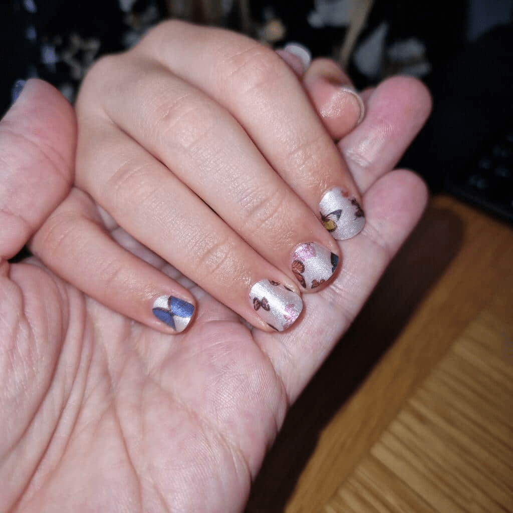 Silver kids' nail wraps with butterfly print and blue geometric accent nail, Mini Me design.
