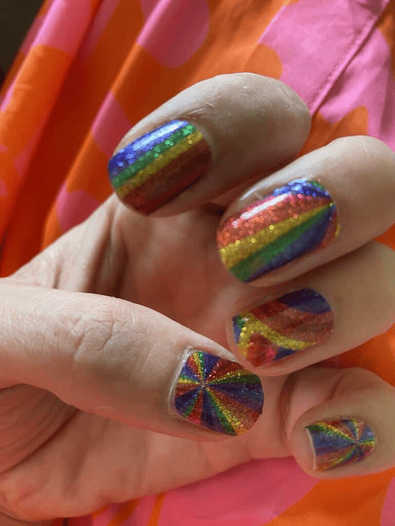 Kids' nail wraps in glittery rainbow stripes and radiating sunburst pattern, high-shine finish.