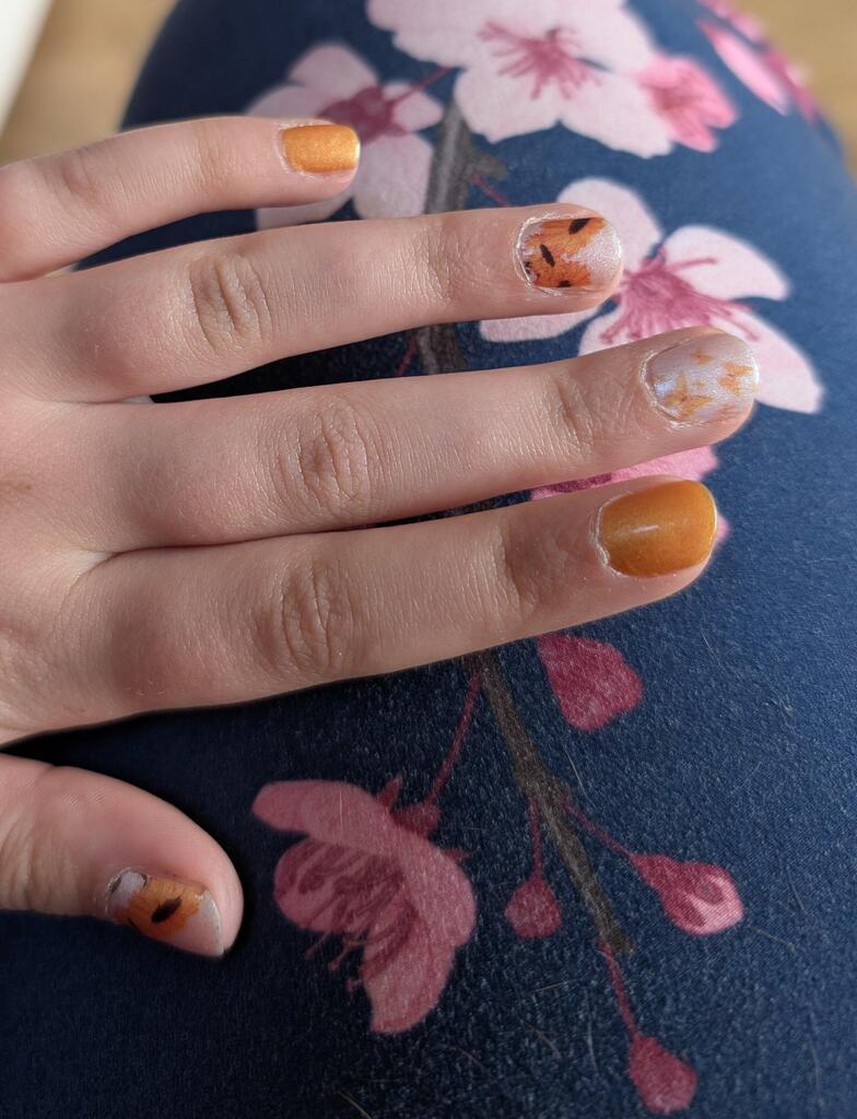 Child wearing orange yellow sunflower kids nail wraps on small fingers Mini Me