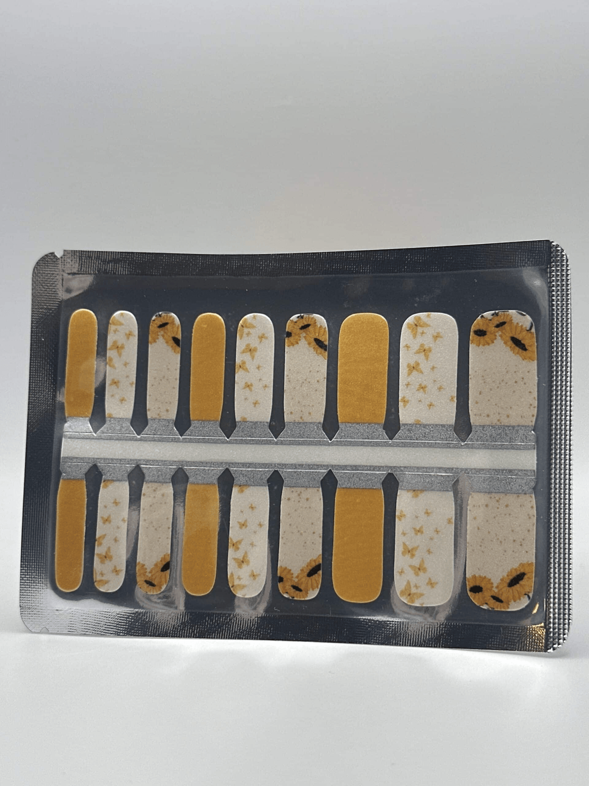 Kids nail wraps with yellow sunflower and butterfly patterns in packaging