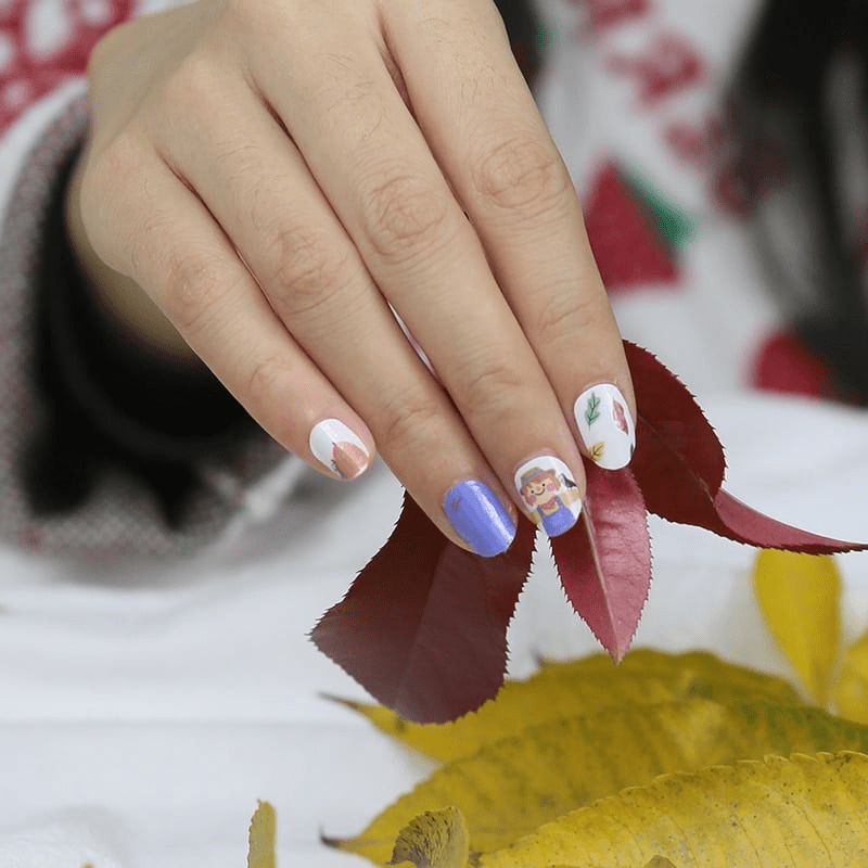 Kids nail art wraps with blue and autumn harvest character patterns on hand
