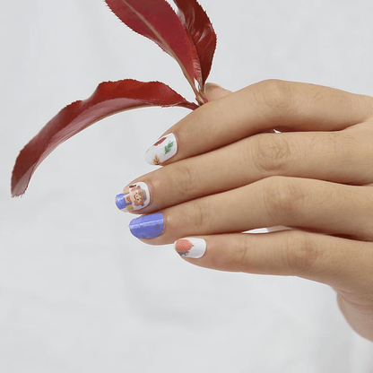 Children's nail wraps on hand with blue and autumn pumpkin character nail art