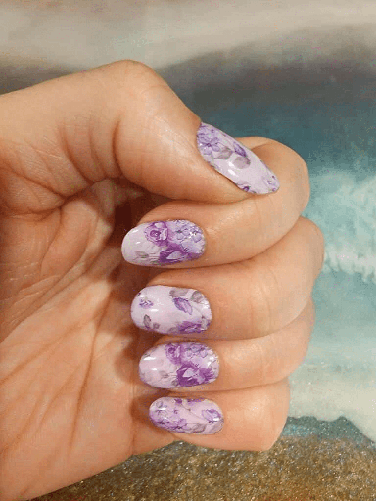 Lavender rose nail wraps on fingertips displaying floral at-home manicure