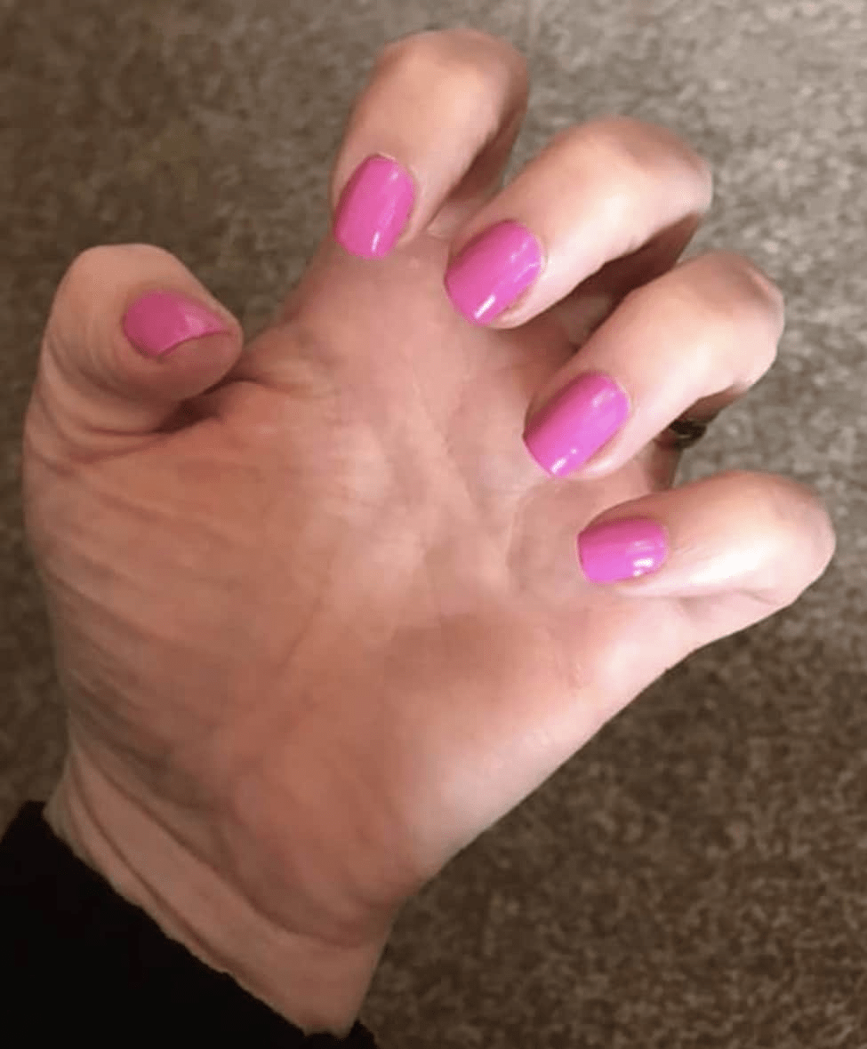 Pink glossy nail wraps on hand showing solid colour at-home manicure