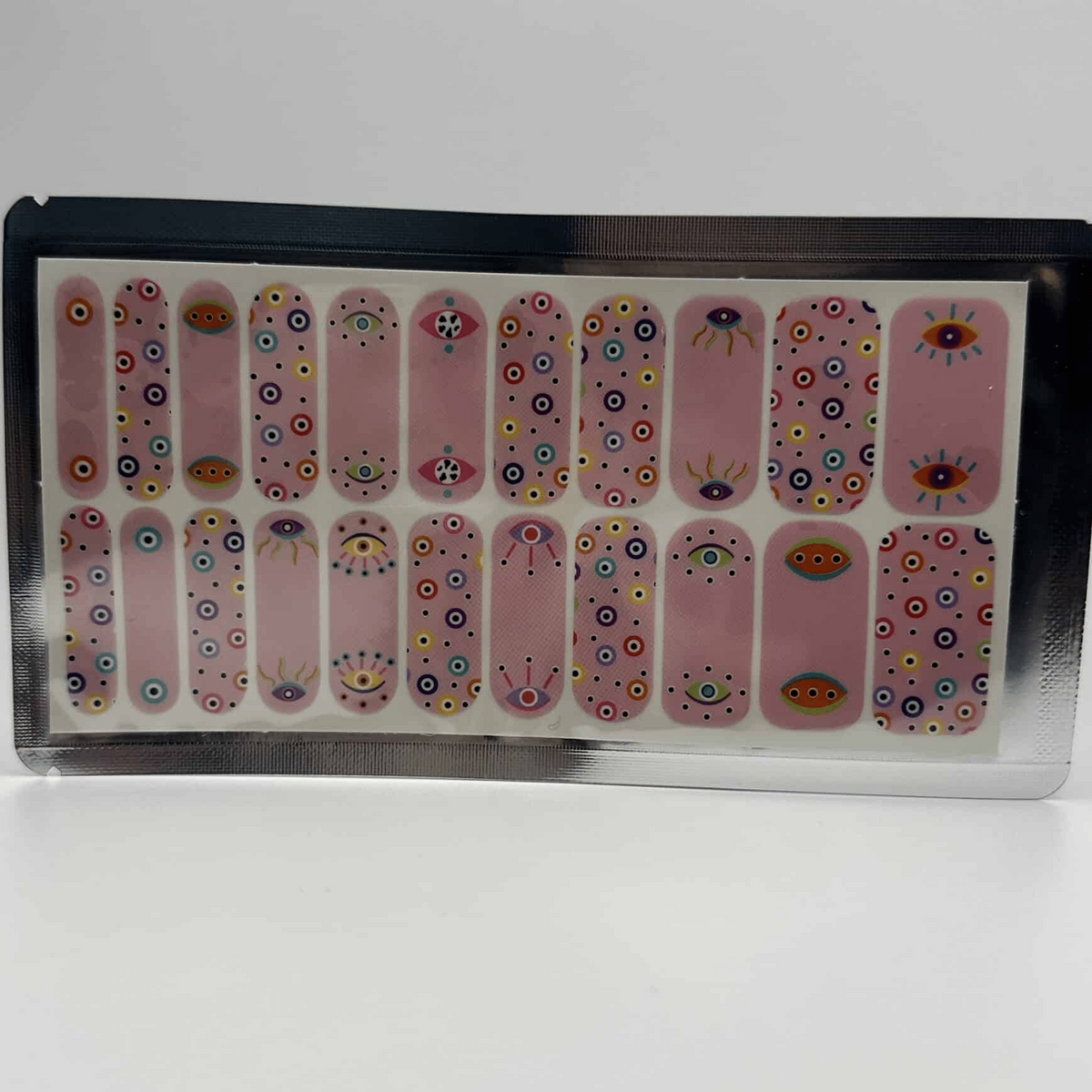 Pink nail wraps with mystical all-seeing eye pattern in wide fit packaging for nail art