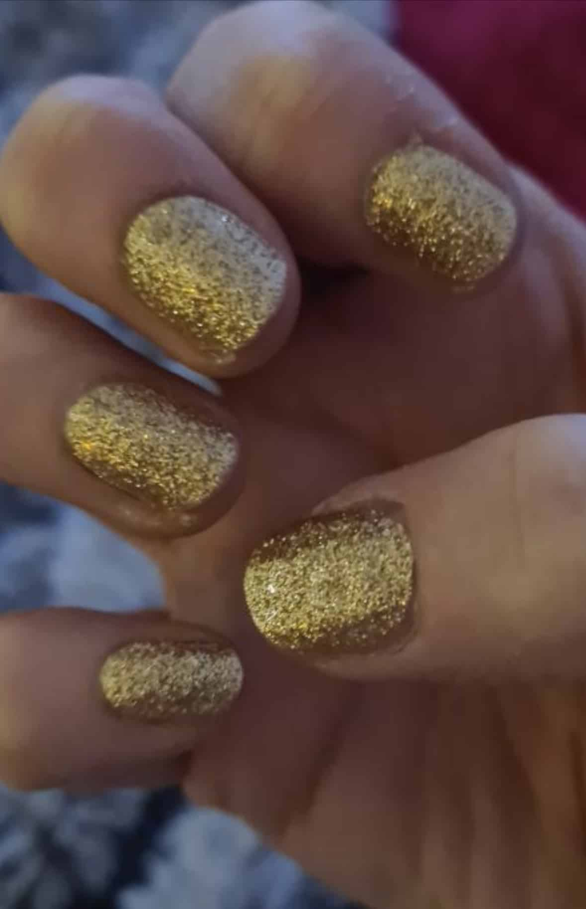 Gold glitter nail wraps with textured full-coverage sparkle finish on short round nails
