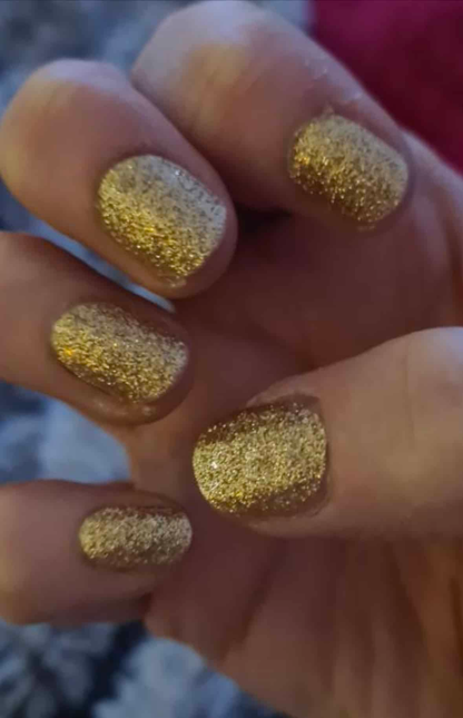 Gold glitter nail wraps with textured full-coverage sparkle finish on short round nails