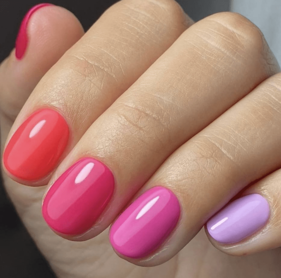 Glossy nail wraps in coral, pink, magenta and lilac gradient shades on short round nails