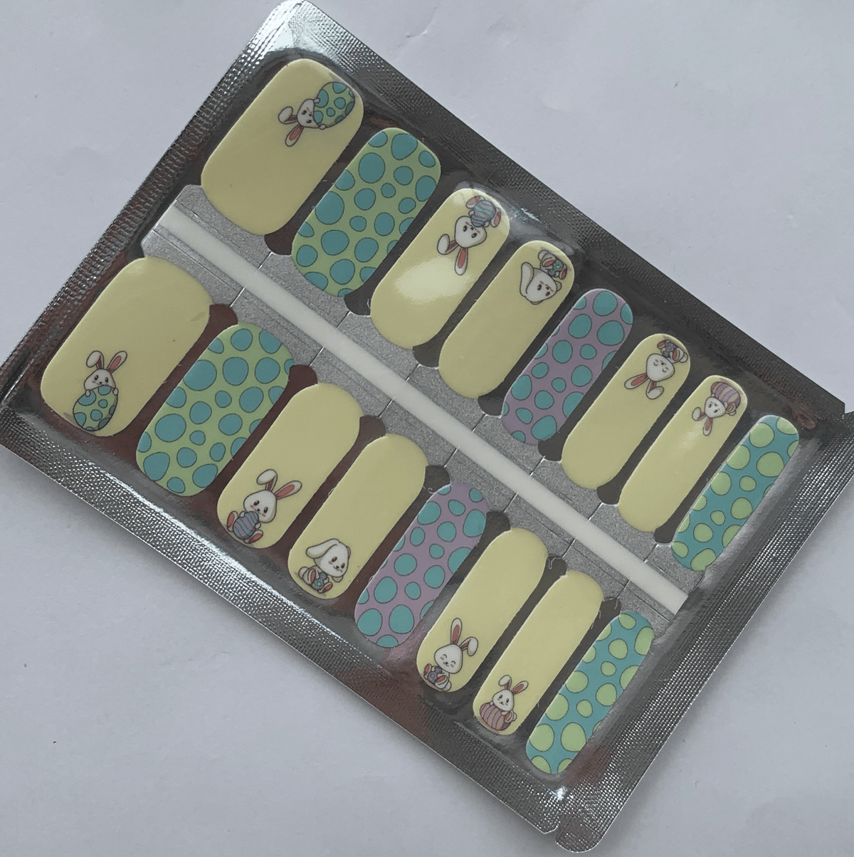 Non-UV nail wraps packaging showing blue and yellow bunny design manicure wraps in foil packet