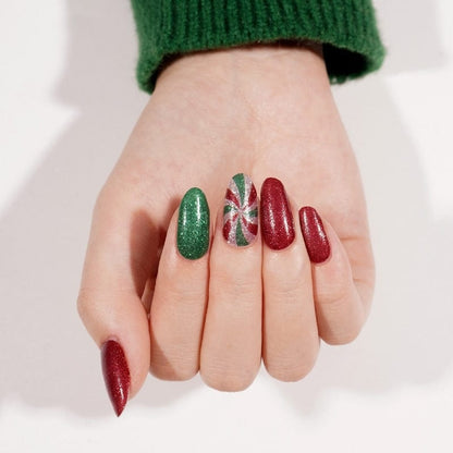 Holiday manicure featuring red and green glitter nail wraps with candy cane accent nails