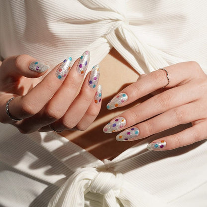 Long almond nails with silver metallic nail wraps featuring colourful dot pattern on hands