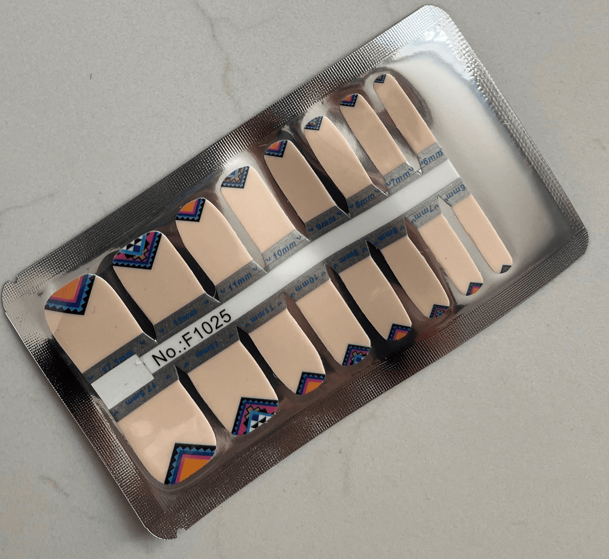 Aztec pattern pedicure nail wraps sheet showing geometric tribal designs in coral blue tones