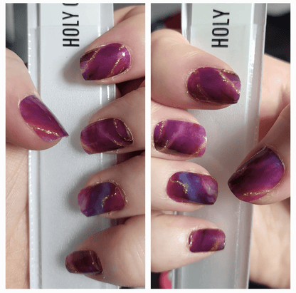 Purple amethyst marble nail wraps on hand showing glossy stone pattern finish