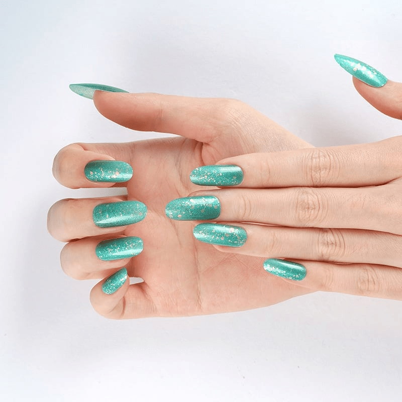 Turquoise glitter nail wraps on hand showing sparkly green at-home manicure finish
