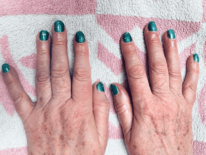 Hands wearing turquoise holographic glitter nail wraps with metallic cosmic sparkle finish