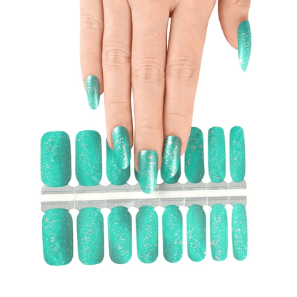 Hand selecting from turquoise glitter nail wrap sheet showing individual wrap sizes