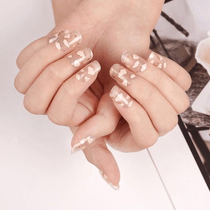 Transparent pink cloud pattern nail wraps on hands creating celestial nail art design