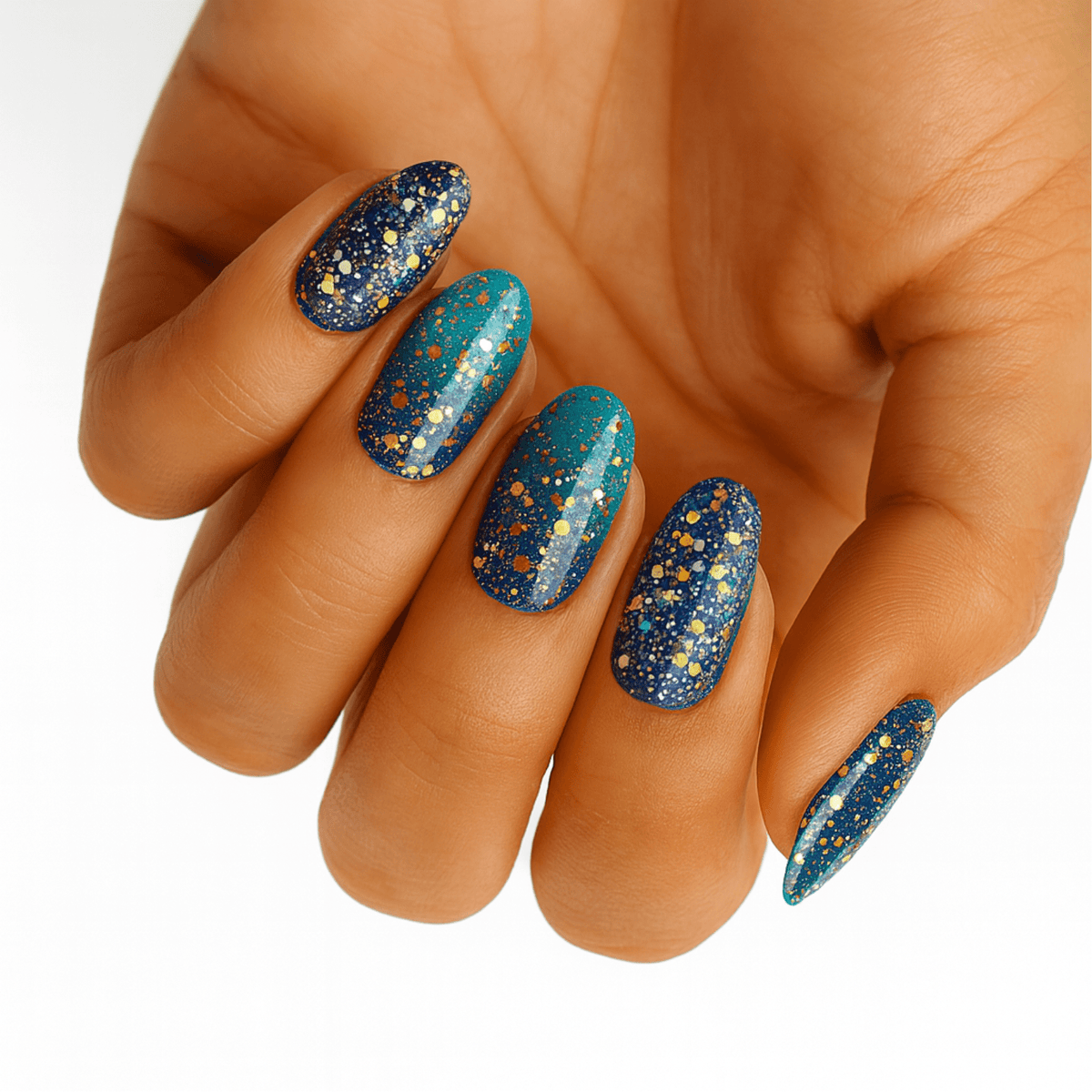 Navy and teal nail wraps with gold and silver glitter in a starry pattern