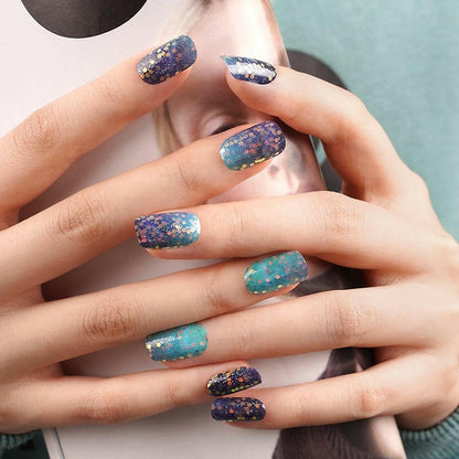 Hands displaying blue to teal glitter ombre nail wraps with sparkly gradient finish
