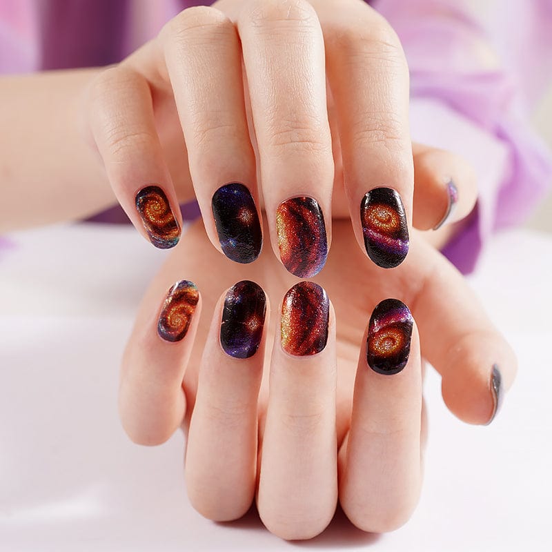 Space galaxy nail art wraps on hands displaying cosmic nebula design manicure