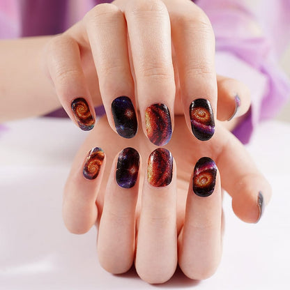 Space galaxy nail art wraps on hands displaying cosmic nebula design manicure