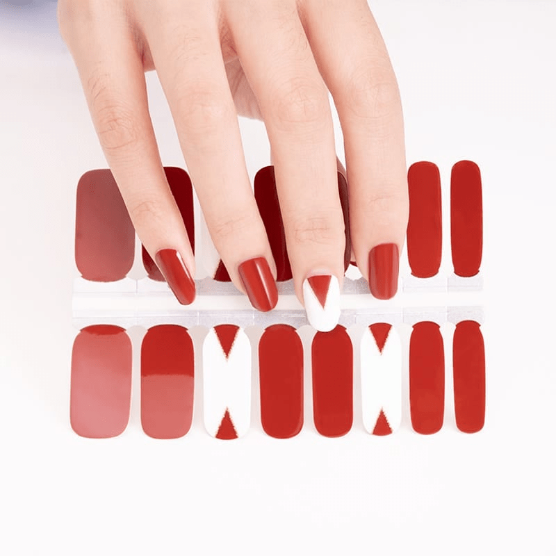 Red matte nail wraps with geometric cutout patterns for at-home manicure