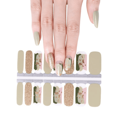 Hand displaying sage green floral nail wraps with gold glitter and pink flower patterns