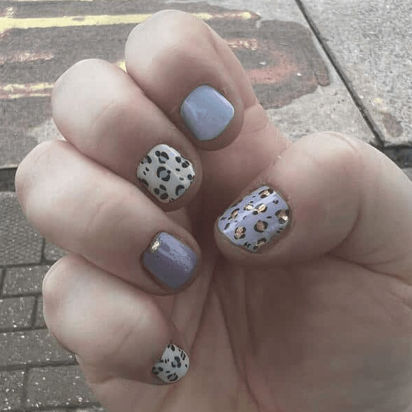 Blue and grey leopard print nail wraps on hand showing at-home manicure design
