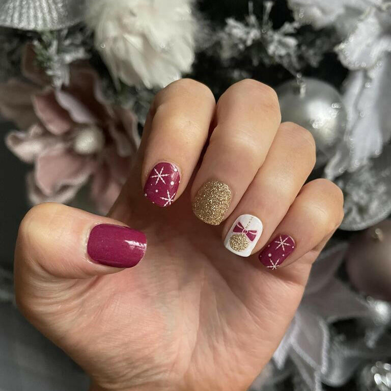 Berry nail wraps with snowflakes, gold glitter accent and white bauble bow design