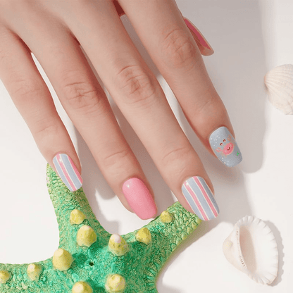 Hand showing pink and blue seaside nail wraps with crab and stripe patterns
