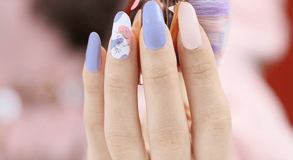 Blue and pink floral nail wraps on hand showing delicate botanical nail art design