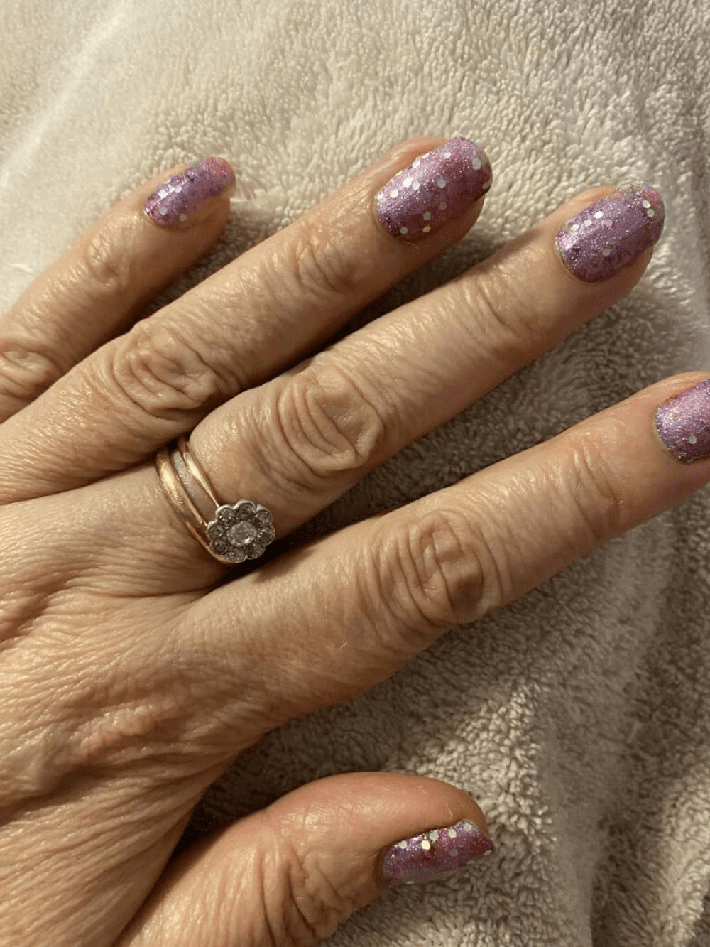 Mauve-pink nail wraps with chunky silver and purple glitter on short round nails