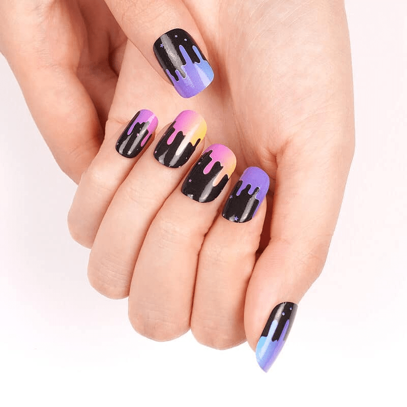 Hands displaying vibrant gradient nail wraps featuring black paint drip nail art design