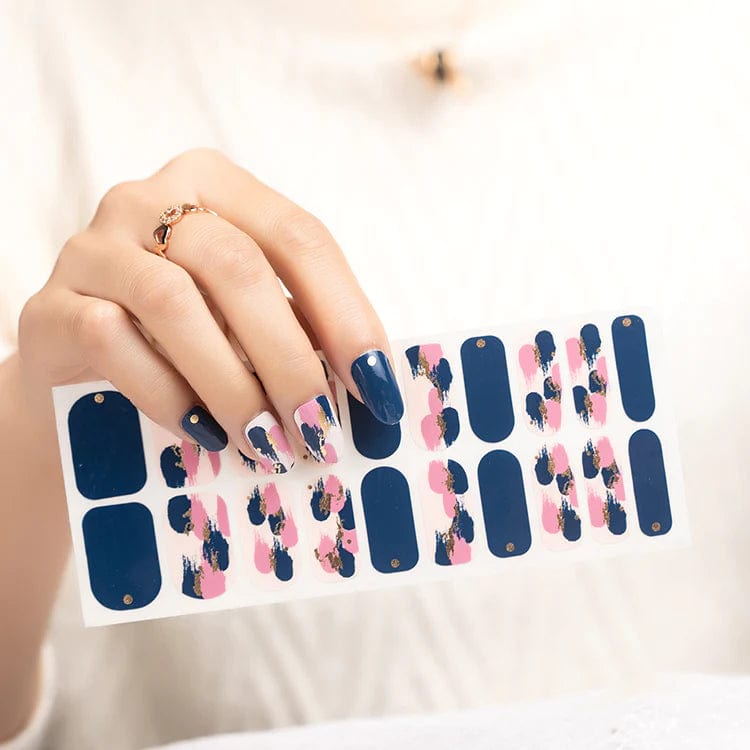 Hand holding blue and pink floral nail wraps sheet for at-home manicure application