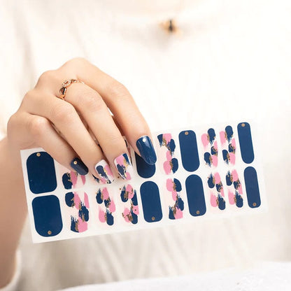 Hand holding blue and pink floral nail wraps sheet for at-home manicure application