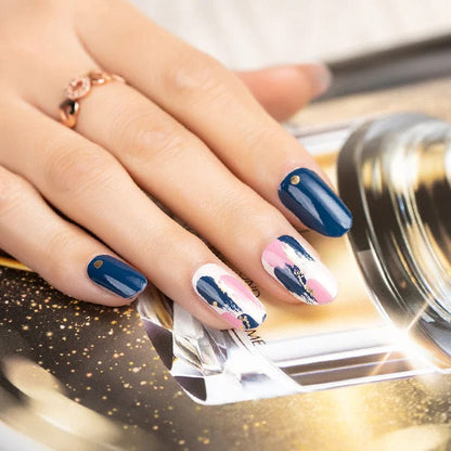Hand wearing blue and pink floral pattern nail wraps with abstract art design
